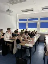 Uczestnicy warsztatów naukowych w ramach projektu Zdolni z Pomorza 2.0 siedzą przy ławkach w sali dydaktycznej