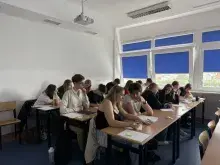 Uczestnicy warsztatów naukowych w ramach projektu Zdolni z Pomorza 2.0 siedzą przy ławkach w sali dydaktycznej