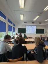 Uczestnicy warsztatów naukowych w ramach projektu Zdolni z Pomorza 2.0 siedzą przy ławkach w sali dydaktycznej